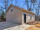 Side view of a detached garage shows the driveway, single door entry, and a small landscaped area at 35 Tracechain, Stockbridge, GA 30281
