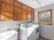Laundry room with wooden cabinets, a utility sink, and a washer and dryer set at 35 Tracechain, Stockbridge, GA 30281