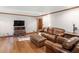 Spacious living room featuring a leather sofa, ottoman, and beautiful hardwood floors at 35 Tracechain, Stockbridge, GA 30281