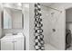 Updated bathroom featuring modern fixtures, a shower with marble-like tile, and a linen storage unit at 5074 Park Ave, Forest Park, GA 30297