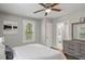 Bedroom featuring a ceiling fan, white bedding, and a glimpse into the adjacent bathroom at 5074 Park Ave, Forest Park, GA 30297