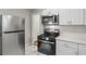 Modern kitchen featuring stainless steel refrigerator and gas range with white subway tile backsplash at 5074 Park Ave, Forest Park, GA 30297