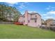 Large, well-maintained backyard with lush green grass, trees, and a cozy deck area for entertaining at 7847 Wrotham Cir, Atlanta, GA 30349