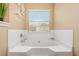 Bathroom with tiled walls, large soaking tub, and updated fixtures at 7847 Wrotham Cir, Atlanta, GA 30349