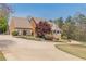 Beautiful brick home with a large manicured lawn, flowering trees, and a long driveway at 8906 E Carroll Rd, Winston, GA 30187