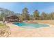 Stunning pool area with pavilion and lounge area surrounded by mature trees, ideal for relaxation at 8906 E Carroll Rd, Winston, GA 30187