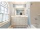 The bathroom features a window, tiled walls, a large mirror above the vanity, and updated fixtures at 1209 The By Ne Way, Atlanta, GA 30306