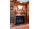 Close-up of library fireplace with black marble hearth and built-in bookcases with books at 1209 The By Ne Way, Atlanta, GA 30306