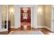 Foyer view to library with hardwood floors, chandelier, built-in shelves and two red chairs at 1209 The By Ne Way, Atlanta, GA 30306