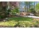 Sprawling backyard with stone bench sitting atop a circular lawn and lush gardens at 1209 The By Ne Way, Atlanta, GA 30306