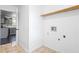 Bright laundry room with tiled floor, wooden shelf and hookups for washer and dryer at 2560 Ashley Downs Ln, South Fulton, GA 30349