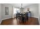 This dining room features hardwood floors, a modern chandelier, and natural light from the nearby window at 1064 Brooks Rackley Rd, Dallas, GA 30157