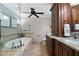 This main bathroom has stone tile flooring, a soaking tub, a glass enclosed shower, and dual vanities at 1064 Brooks Rackley Rd, Dallas, GA 30157