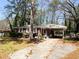Exterior view of a brick house with a carport surrounded by mature trees at 2567 Connally Dr, East Point, GA 30344