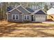 Charming gray home with stone accents and a two-car garage provides comfortable living in a serene setting at 5328 Monticello Dr, Villa Rica, GA 30180