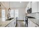 Well-lit kitchen featuring white cabinets, granite countertops, and stainless steel appliances at 5328 Monticello Dr, Villa Rica, GA 30180