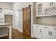 Kitchen displays sliding barn door, granite counters, and white cabinets with glass inserts at 5328 Monticello Dr, Villa Rica, GA 30180