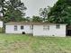 Backyard of this home featuring lush green grass and mature trees at 908 Kennesaw Dr, Forest Park, GA 30297