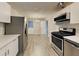 Modern kitchen featuring stainless steel appliances, white cabinets and countertops, and new flooring at 908 Kennesaw Dr, Forest Park, GA 30297