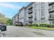 Multi-story condo building with balconies, well-maintained landscaping, and parking in front, offering a sophisticated urban living experience at 3201 Lenox Rd Ne # 13, Atlanta, GA 30324