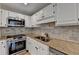 Modern kitchen features stainless steel appliances, granite countertops, and white cabinets at 3201 Lenox Rd Ne # 13, Atlanta, GA 30324
