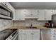 Well-lit kitchen with white cabinets, stainless steel appliances, and stone tile backsplash at 3201 Lenox Rd Ne # 13, Atlanta, GA 30324