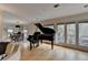 Elegant living room with a grand piano, hardwood floors, and access to a balcony at 3201 Lenox Rd Ne # 13, Atlanta, GA 30324