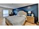 Inviting main bedroom with a blue accent wall, dresser and bedside table at 3201 Lenox Rd Ne # 13, Atlanta, GA 30324