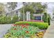Community entrance with 'The James' signage, mature trees, vibrant flowers, and manicured landscaping creating an inviting first impression at 3201 Lenox Rd Ne # 13, Atlanta, GA 30324