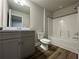 Bright bathroom featuring a tub with shower, wood-look flooring, and a gray vanity with a light countertop at 6420 Olmadison Pl, Atlanta, GA 30349