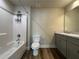 Bright bathroom featuring a tub with shower, wood-look flooring, and a gray vanity with a light countertop at 6420 Olmadison Pl, Atlanta, GA 30349