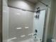 Close up of a shower and tub combo in a bathroom featuring shower caddy and tile surround at 6420 Olmadison Pl, Atlanta, GA 30349