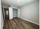 Neutral bedroom with wood-look floors, featuring a closet with bi-fold doors and view to hall and other rooms at 6420 Olmadison Pl, Atlanta, GA 30349