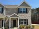 Charming townhome featuring a brick facade, black shutters, and well-maintained landscaping at 6420 Olmadison Pl, Atlanta, GA 30349