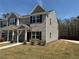 Beautiful home with a well manicured lawn and charming facade, complemented by lush greenery and blue sky at 6420 Olmadison Pl, Atlanta, GA 30349