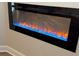 Close-up of a modern electric fireplace featuring sleek black detailing and colorful flame effects at 6420 Olmadison Pl, Atlanta, GA 30349