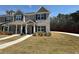 Exterior view displaying the landscaped front yard and well-designed townhome facades at 6420 Olmadison Pl, Atlanta, GA 30349