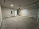 Spacious two car garage with concrete flooring, bright lighting, and automatic door opener at 6420 Olmadison Pl, Atlanta, GA 30349