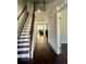 Hallway with wood floors and staircase leading to upper level at 7665 Easton Valley Ln, Cumming, GA 30028