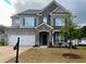 Charming two-story home with a stone and brick facade and well-manicured lawn at 7665 Easton Valley Ln, Cumming, GA 30028