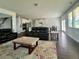 Open living room and kitchen with dark wood floors at 7665 Easton Valley Ln, Cumming, GA 30028