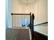 Carpeted staircase with dark wood handrail and wrought iron spindles at 7665 Easton Valley Ln, Cumming, GA 30028