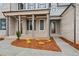 Charming covered front porch with brick columns and meticulous landscaping with flowering plants at 3812 Havenrock Dr, Marietta, GA 30066