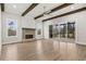 Light filled living room with hardwood floors, brick fireplace, beamed ceiling, and sliding patio doors at 3812 Havenrock Dr, Marietta, GA 30066