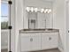 Double vanity bathroom with dark countertops, white cabinets, and a large well lit mirror at 3816 Havenrock Drive, Marietta, GA 30066