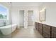 Bright bathroom with a modern soaking tub, walk-in shower, and double vanity with dark wood cabinets at 3819 Havenrock Dr, Marietta, GA 30066