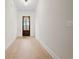 Hallway featuring light hardwood floors, white walls, baseboards, and trim, and a traditional dark wood door at 3819 Havenrock Dr, Marietta, GA 30066