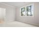 Well-lit bedroom featuring fresh paint, plush carpeting, and a window offering a view of surrounding trees at 3820 Havenrock Dr, Marietta, GA 30066