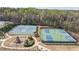 Aerial view of community tennis and basketball courts next to a playground area surrounded by trees at 5965 Ellington Cv, Cumming, GA 30040