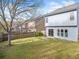 Spacious backyard with a grassy lawn, wooden fence, and a glimpse of the home's exterior at 5965 Ellington Cv, Cumming, GA 30040